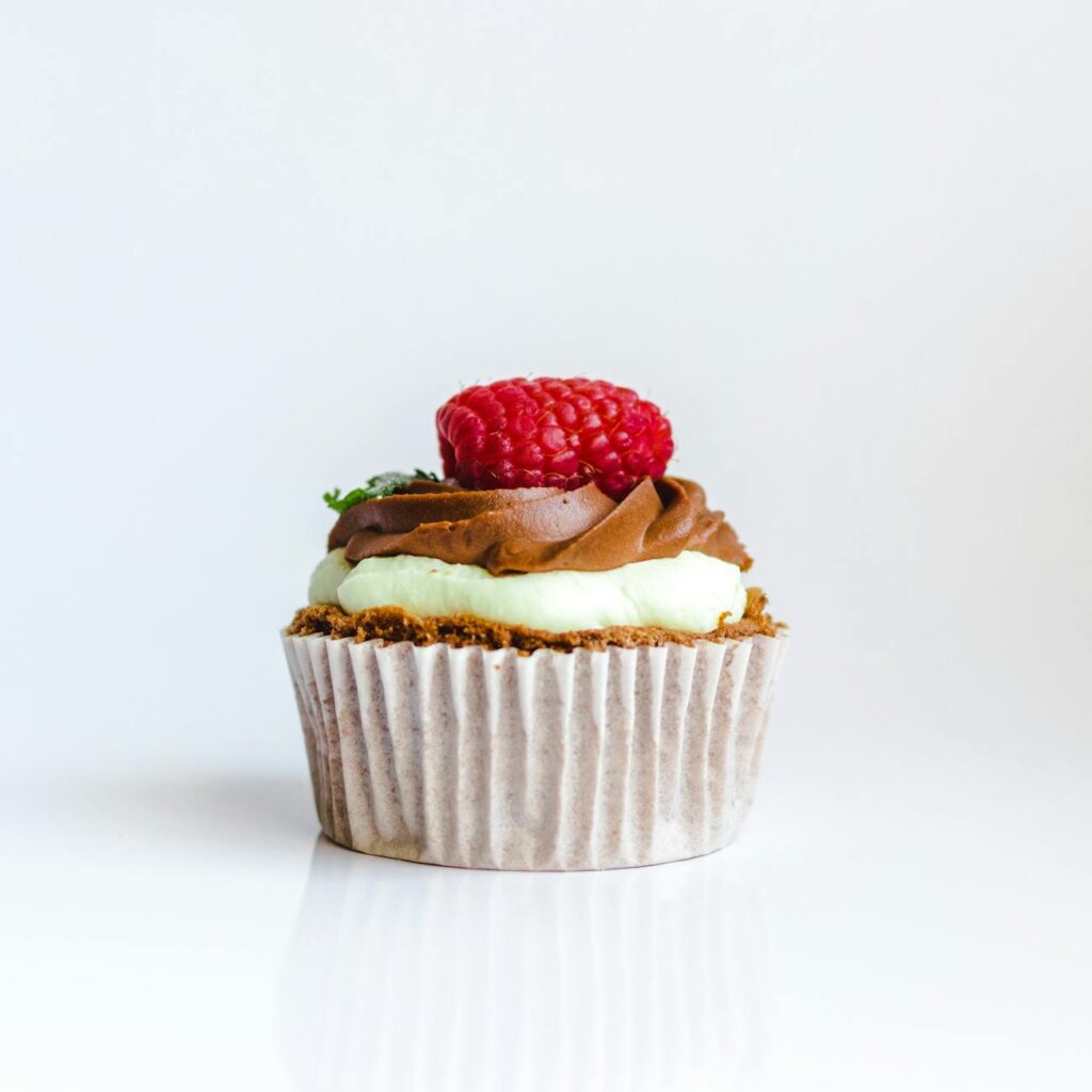 photograph of chocolate cupcake with red strawberry toppings